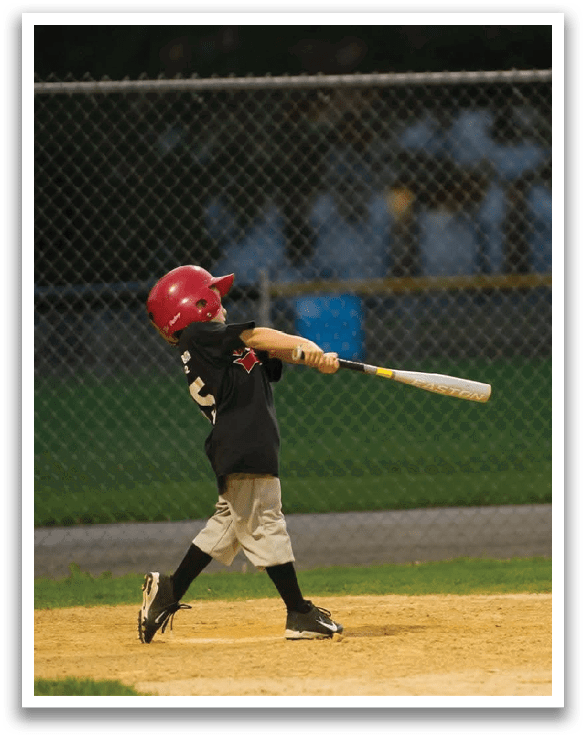 A young boy is swinging a baseball bat on a field. AI generated content