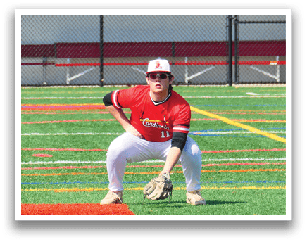 A baseball player is crouched down on the field, wearing a red shirt and white pants. He is holding a baseball glove, ready to catch a ball. AI generated content