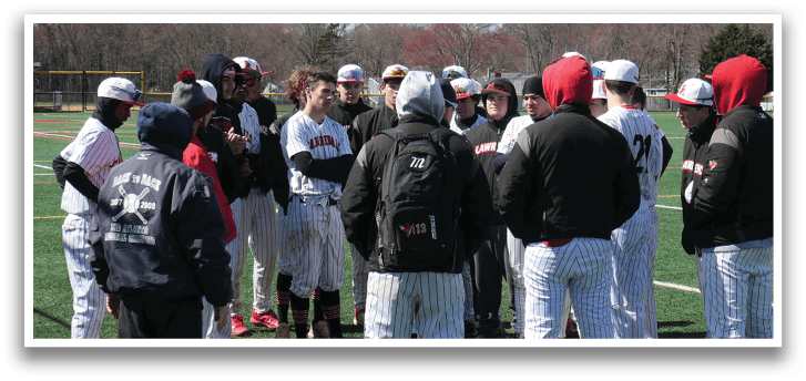A group of baseball players standing on a field. Description generated by AI