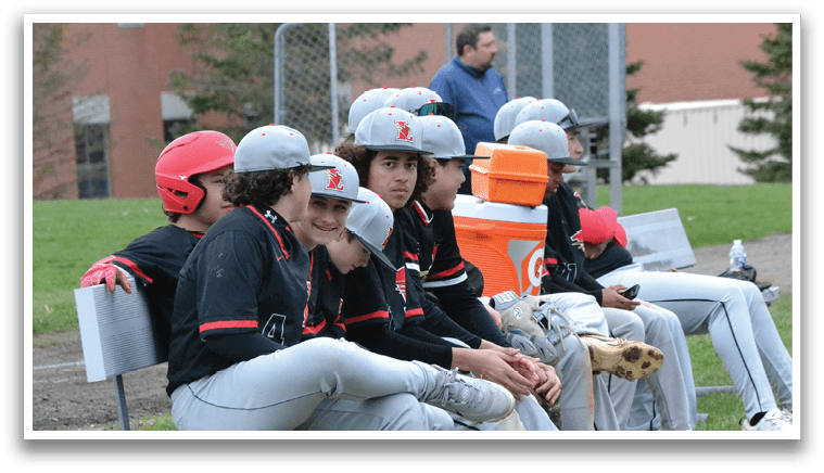 A group of baseball players sitting on a bench. Description generated by AI