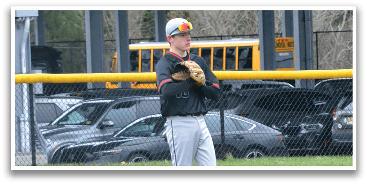 A baseball player is standing in a field with a baseball glove on. Description generated by AI