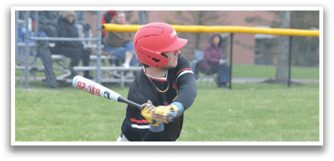 A baseball player in a black shirt and red helmet is swinging a bat at a ball. Description generated by AI