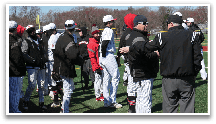 A group of people wearing baseball uniforms are standing on a field. Description generated by AI