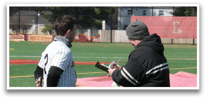 A man wearing a black jacket and a hat is talking to a baseball player. Description generated by AI