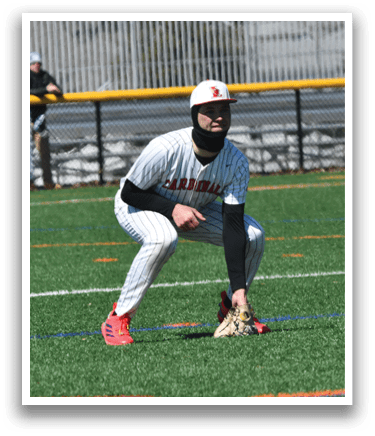 A baseball player in a white and red uniform is kneeling on a baseball field. Description generated by AI