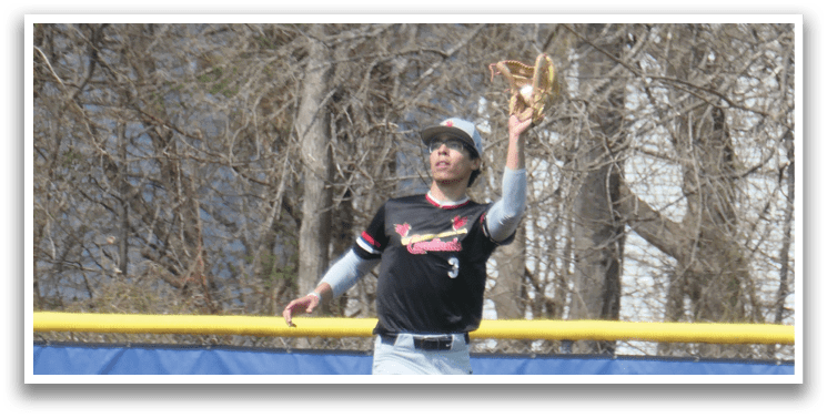 A baseball player wearing a black and red jersey catching a ball. Description generated by AI