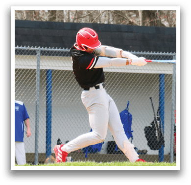 A baseball player in a black shirt and red shoes is swinging a bat. Description generated by AI
