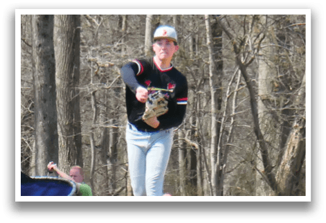 A baseball player in a black and red shirt and grey pants is throwing a ball. Description generated by AI