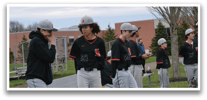A group of baseball players standing on a field. Description generated by AI