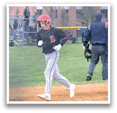 A baseball player wearing a red helmet and white pants is walking across the field. Description generated by AI