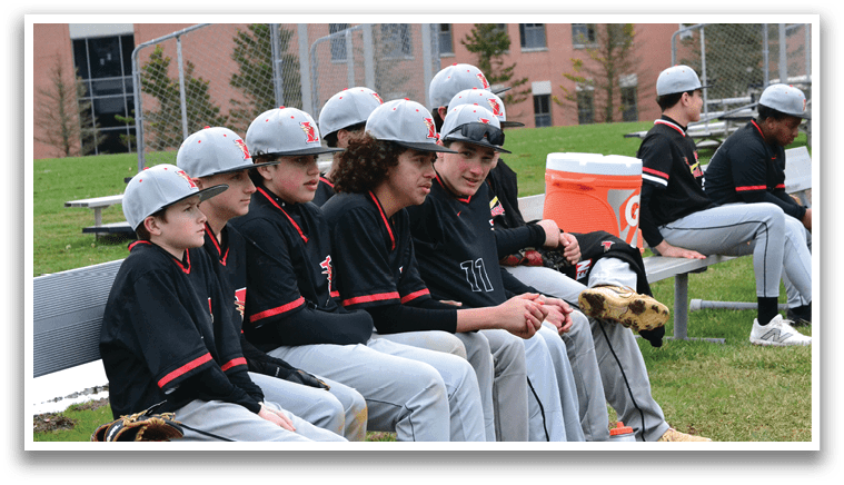 A group of baseball players sitting on a bench. Description generated by AI