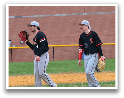 A baseball player wearing a black shirt and red hat. Description generated by AI