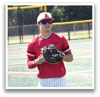 A baseball player wearing a red and white uniform holding a baseball glove. Description generated by AI