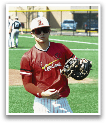 A baseball player wearing a red shirt and white pants. Description generated by AI