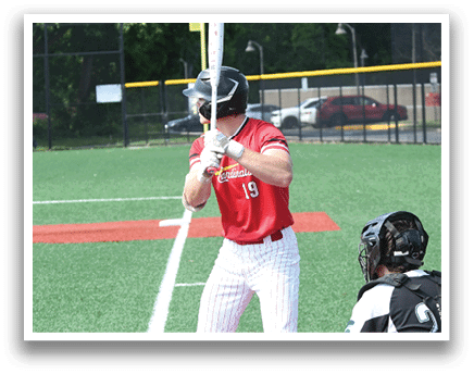 A baseball player is holding a bat and getting ready to hit the ball. Description generated by AI