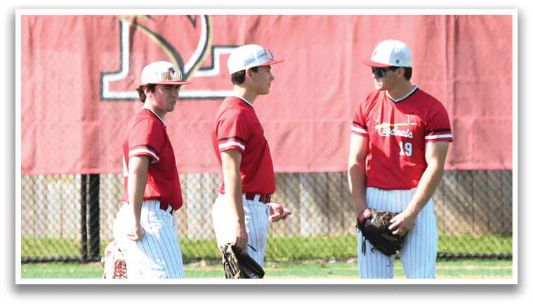 Three baseball players standing on a field. Description generated by AI