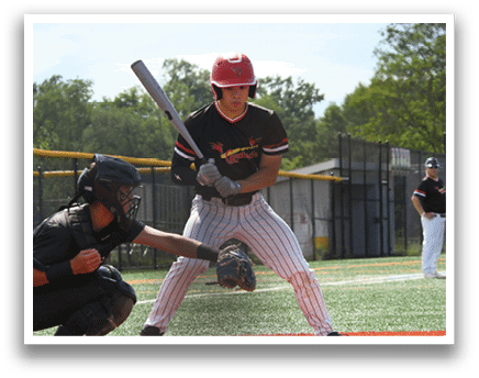 A baseball player in a black and red shirt holding a bat. Description generated by AI