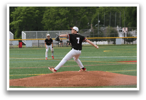 A baseball player in a black shirt and white pants is pitching a ball. Description generated by AI