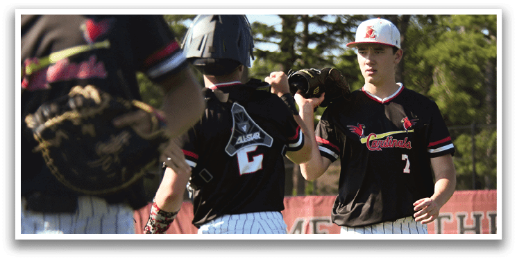 A baseball player in a red helmet and black and white uniform is swinging a bat. Description generated by AI
