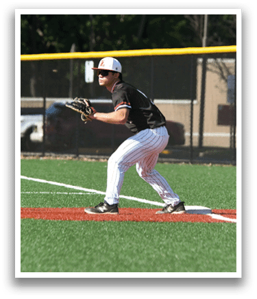 A baseball player is standing in the outfield, wearing a black shirt and white pants. Description generated by AI