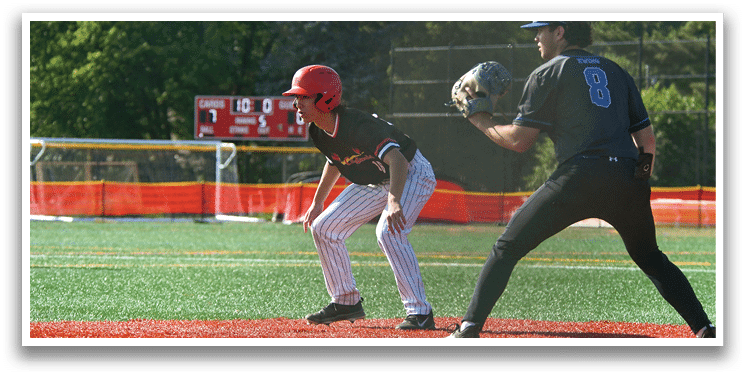 A baseball player wearing a red helmet and black shirt is standing on a field. Description generated by AI
