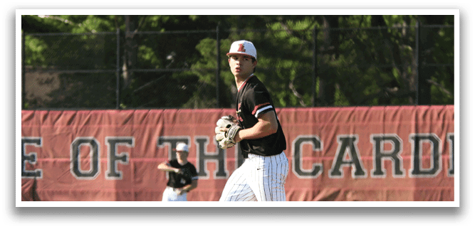 A baseball player in a black shirt and white pants is standing on a field. Description generated by AI