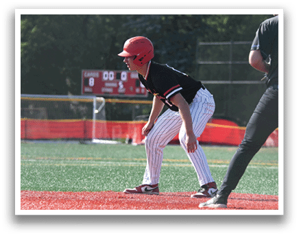A baseball player in a red helmet and black uniform is crouching on the field. Description generated by AI