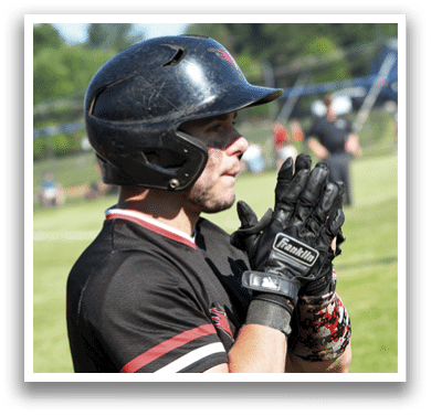 A baseball player wearing a red shirt and black helmet. Description generated by AI