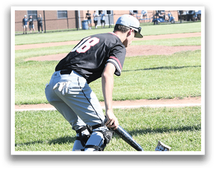 A baseball player in a red shirt and helmet holding a bat. Description generated by AI
