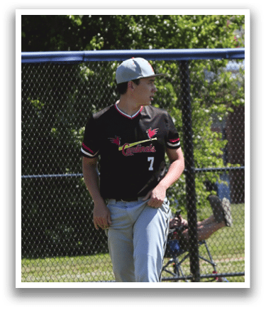 A baseball player wearing a red shirt and white pants. Description generated by AI
