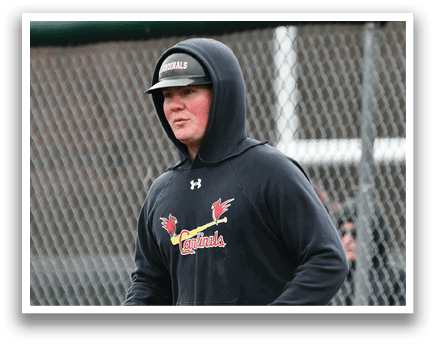 A man wearing a black hoodie with a red bird on it. Description generated by AI
