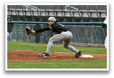 A baseball player in a black shirt and grey pants is sliding into a base. Description generated by AI