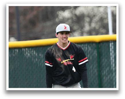 A baseball player wearing a black and red shirt and grey pants. Description generated by AI