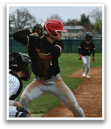 A baseball player in a black shirt and red helmet is swinging a bat. Description generated by AI