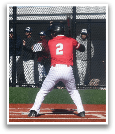 A baseball player is at bat, wearing a red shirt and white pants. Description generated by AI