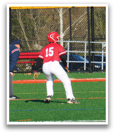 A baseball game is taking place on a field with a man in a red shirt and white pants holding a bat. Description generated by AI