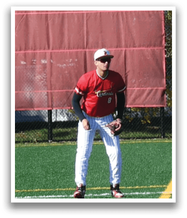 A man wearing a red shirt and white pants is standing on a baseball field. Description generated by AI