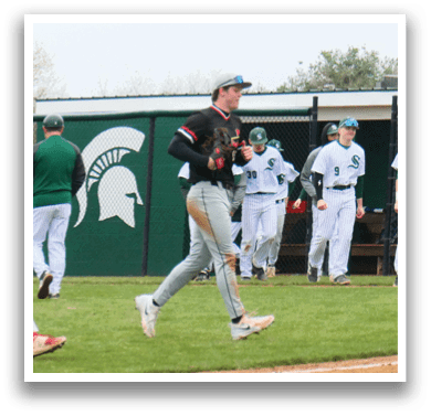 Baseball players wearing green and white uniforms. Description generated by AI