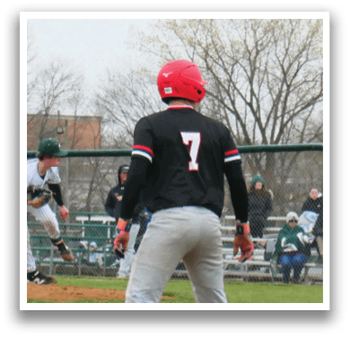 A baseball game is taking place with a player in a black shirt and red shoes standing on the field. Description generated by AI