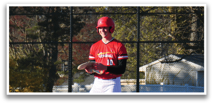 A baseball player in a red and white uniform is standing on a baseball field. Description generated by AI