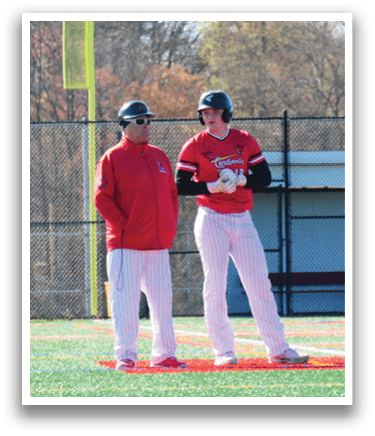 Two men standing on a baseball field. Description generated by AI