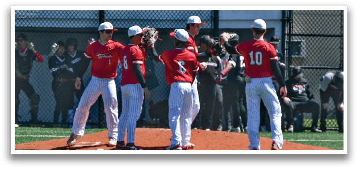 A group of people wearing red shirts and white pants standing on a baseball field. Description generated by AI