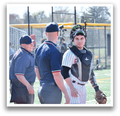 A baseball player wearing a helmet and catcher's gear. Description generated by AI