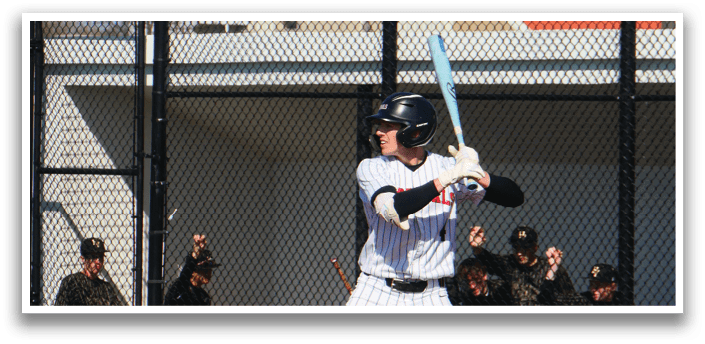 A baseball player in a white and black uniform holding a bat. Description generated by AI