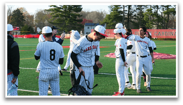 A group of baseball players standing on a field. Description generated by AI