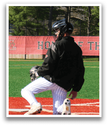 A baseball player in a black jacket and white pants is squatting on the field. Description generated by AI