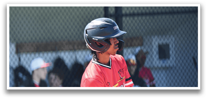 A baseball player wearing a red jersey and a black helmet. Description generated by AI
