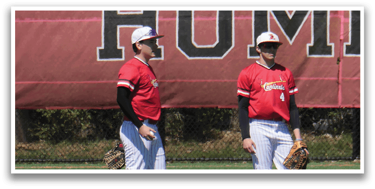 Three baseball players standing on a field. Description generated by AI
