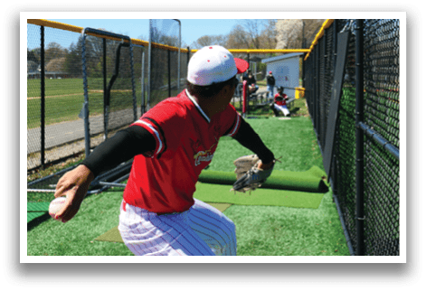 A baseball player in a red shirt and white pants is throwing a ball. Description generated by AI