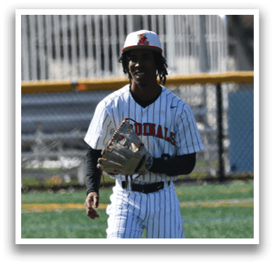 A baseball player in a white and red uniform is standing on a field. Description generated by AI
